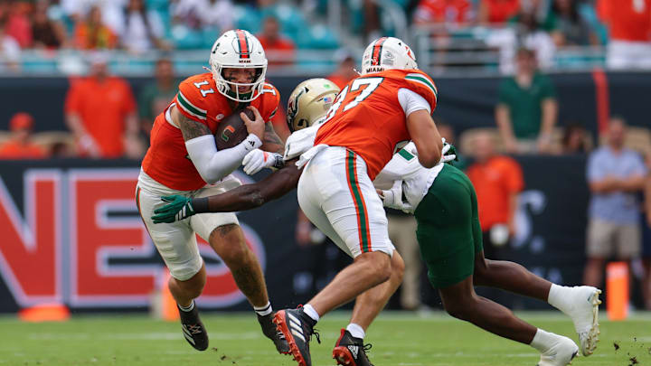 Sep 13, 2025; Miami Gardens, Florida, USA; Miami Hurricanes quarterback Carson Beck (11) runs with the ball against the South Florida Bulls in the first quarter at Hard Rock Stadium. Mandatory Credit: Nathan Ray Seebeck-Imagn Images