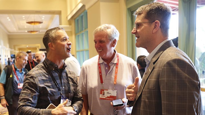 Mar 25, 2024; Orlando, FL, USA;  Baltimore Ravens head coach John Harbaugh speaks to his brother Los Angeles Chargers head coach Jim Harbaugh during the NFL annual league meetings at the JW Marriott. Mandatory Credit: Nathan Ray Seebeck-Imagn Images