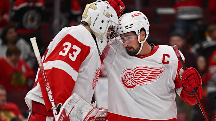 Oct 1, 2022; Chicago, Illinois, USA; Detroit Red Wings goaltender Sebastian Cossa (33) and forward Dylan Larkin (71) celebrate their 3-0 win over the Chicago Blackhawks at the United Center. Mandatory Credit: Jamie Sabau-Imagn Images