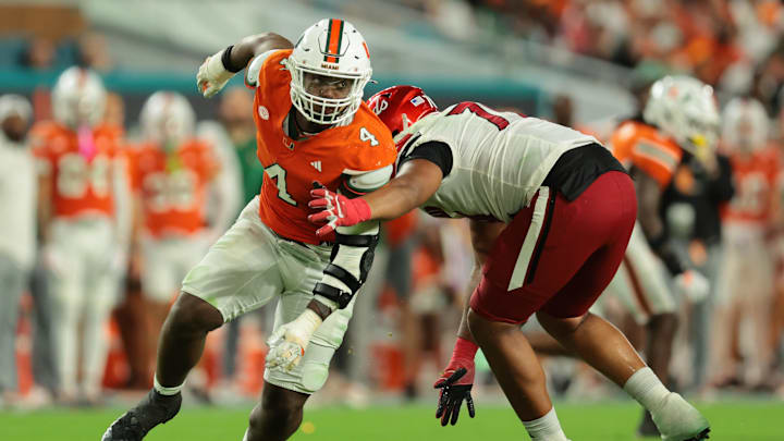 Oct 17, 2025; Miami Gardens, Florida, USA; Miami Hurricanes defensive lineman Rueben Bain Jr. (4) escapes coverage against Louisville Cardinals offensive lineman Trevonte Sylvester (70) during the third quarter at Hard Rock Stadium. Mandatory Credit: Sam Navarro-Imagn Images