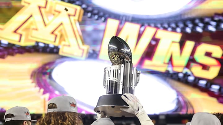 Dec 29, 2022; Bronx, NY, USA; Minnesota Golden Gophers players hold the championship trophy in front of the main scoreboard after the 2022 Pinstripe Bowl against the Syracuse Orange at Yankee Stadium. Mandatory Credit: Vincent Carchietta-Imagn Images