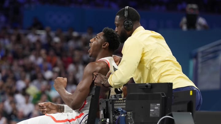 Jul 30, 2024; Villeneuve-d'Ascq, France; Dwyane Wade rubs the shoulders of Canada small forward RJ Barrett (9) against Australia in a men's group stage basketball match during the Paris 2024 Olympic Summer Games at Stade Pierre-Mauroy. Mandatory Credit: John David Mercer-USA TODAY Sports Jul 30, 2024; Villeneuve-d'Ascq, France; Dwyane Wade rubs the shoulders of Canada small forward RJ Barrett (9) against Australia in a men's group stage basketball match during the Paris 2024 Olympic Summer Games at Stade Pierre-Mauroy. Mandatory Credit: John David Mercer-USA TODAY Sports