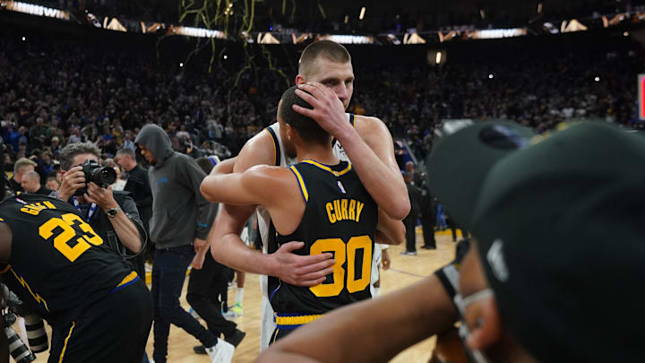 Apr 27, 2022; San Francisco, California, USA; Denver Nuggets center Nikola Jokic (15) and Golden State Warriors guard Stephen Curry (30) hug after game five of the first round for the 2022 NBA playoffs at Chase Center. 