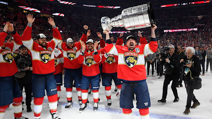 Brad Marchand holds the Stanley Cup trophy while his Florida Panthers teammates celebrate. 