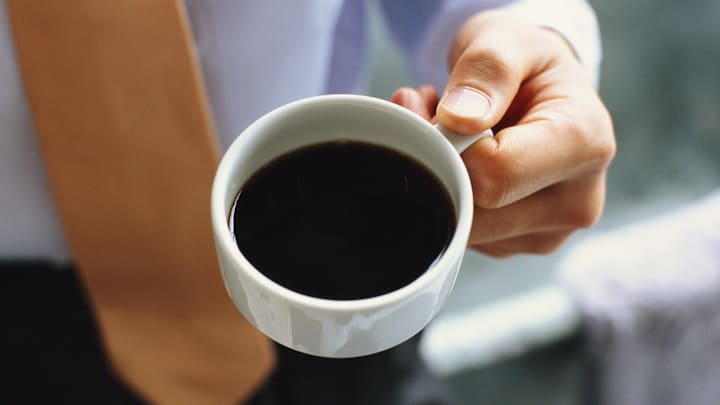 Businessman holding cup of black coffee