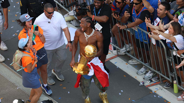 The Oklahoma City Thunder guard Shai Gilgeous-Alexander carries the Larry O'Brien trophy and celebrates their first NBA Finals title win with a champions parade throughout downtown Oklahoma City on Tuesday, June 24, 2025.  Mandatory Credit: Steve Sisney/USA TODAY NETWORK via Imagn Images