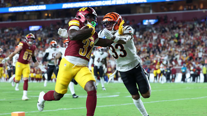 Washington Commanders running back Jacory Croskey-Merritt (32) scores a touchdown as Cincinnati Bengals safety Daijahn Anthony (33) defends during the first half at Northwest Stadium. 