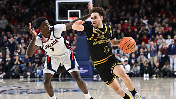 Jan 24, 2026; Spokane, Washington, USA; San Francisco Dons guard Ryan Beasley (0) runs the lane against Gonzaga Bulldogs guard Tyon Grant-Foster (7) in the second half at McCarthey Athletic Center. Gonzaga Bulldogs won 68-66. Mandatory Credit: James Snook-Imagn Images