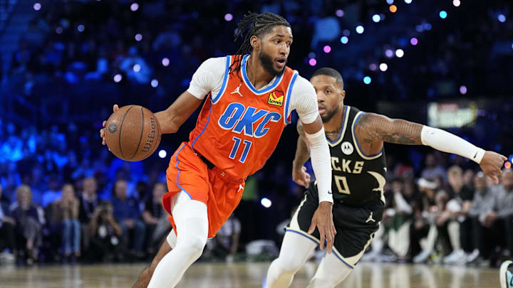 Dec 17, 2024; Las Vegas, Nevada, USA; Oklahoma City Thunder guard Isaiah Joe (11) dribbles against Milwaukee Bucks guard Damian Lillard (0) during the 1st quarter of the Emirates NBA Cup championship game at T-Mobile Arena. Mandatory Credit: Kyle Terada-Imagn Images
