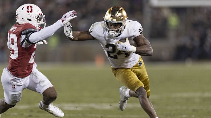 Nov 29, 2025; Stanford, California, USA; Notre Dame Fighting Irish running back Jadarian Price (24) runs with the football against Stanford Cardinal safety Darrius Davis (29) during the first quarter at Stanford Stadium. Mandatory Credit: Stan Szeto-Imagn Images Nov 29, 2025; Stanford, California, USA; Notre Dame Fighting Irish running back Jadarian Price (24) runs with the football against Stanford Cardinal safety Darrius Davis (29) during the first quarter at Stanford Stadium. Mandatory Credit: Stan Szeto-Imagn Images