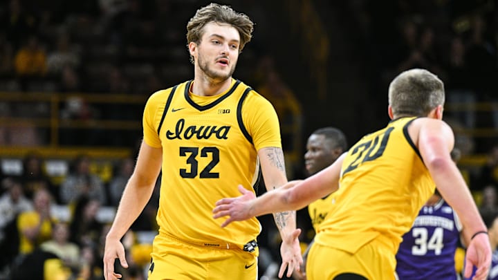Iowa's Owen Freeman (32) high-fives Payton Sandfort (20) against Northwestern at Carver-Hawkeye Arena. 