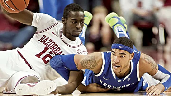 Arkansas Razorbacks guard Fred Gulley III (12) looks at Kentucky Wildcats forward Willie Cauley-Stein (15) following a scramble for a loose ball during a game at Bud Walton Arena. Arkansas defeated Kentucky 73-60. Arkansas Razorbacks guard Fred Gulley III (12) looks at Kentucky Wildcats forward Willie Cauley-Stein (15) following a scramble for a loose ball during a game at Bud Walton Arena. Arkansas defeated Kentucky 73-60.