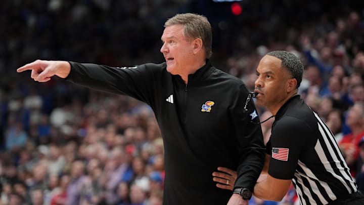 Jan 25, 2025; Lawrence, Kansas, USA; An official restrains Kansas Jayhawks head coach Bill Self against the Houston Cougars during overtime at Allen Fieldhouse. Mandatory Credit: Denny Medley-Imagn Images