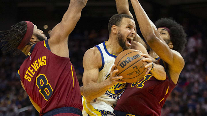 Golden State Warriors guard Stephen Curry (30) is fouled as he drives to the basket between Cleveland Cavaliers forward Lamar Stevens (8) and center Jarrett Allen (31) during the third quarter at Chase Center. Mandatory Credit: D. Ross Cameron-Imagn Images