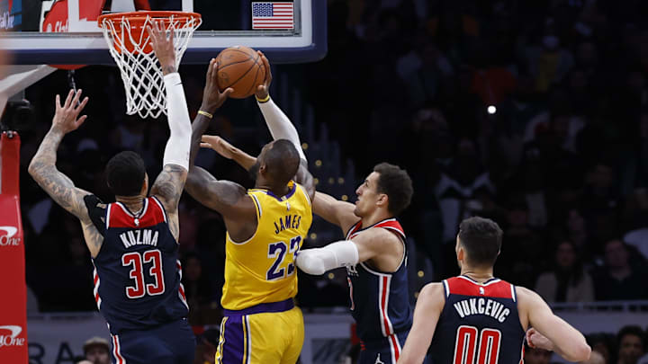 Apr 3, 2024; Washington, District of Columbia, USA; Los Angeles Lakers forward LeBron James (23) shoots the ball as Washington Wizards forward Kyle Kuzma (33) and Wizards forward Patrick Baldwin Jr. (7) defend in the second half at Capital One Arena. Mandatory Credit: Geoff Burke-Imagn Images