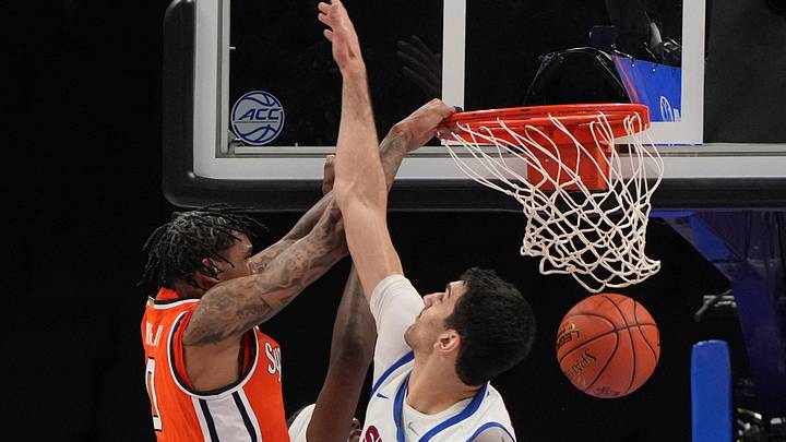 Mar 10, 2026; Charlotte, NC, USA; Syracuse Orange forward Sadiq White Jr. (0) scores as Southern Methodist University Mustangs center Samet Yigitoglu (24) defends in the second half at Spectrum Center. Mandatory Credit: Bob Donnan-Imagn Images Mar 10, 2026; Charlotte, NC, USA; Syracuse Orange forward Sadiq White Jr. (0) scores as Southern Methodist University Mustangs center Samet Yigitoglu (24) defends in the second half at Spectrum Center. Mandatory Credit: Bob Donnan-Imagn Images