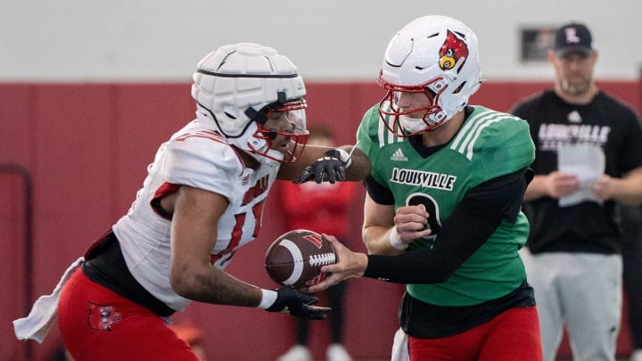 Louisville football quarterback Tyler Shough (9) and running back Peny Boone (13) run drills during