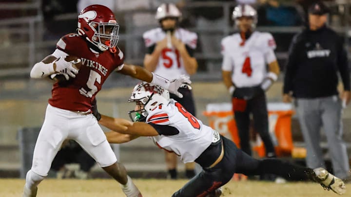 Raines High School running back Tadarius Washington (5) sheds Bishop Kenny Austin Green (8) in the second quarter. Raines High School hosted Bishop Kenny in the Class 3A high school football playoffs at Raines High School Friday night, November 28, 2025 in Jacksonville, Fla. Raines defeated Bishop Kenny 61-15. [Doug Engle/Florida Times-Union]