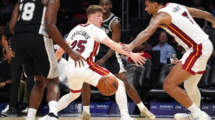 Oct 8, 2025; Miami, Florida, USA;  San Antonio Spurs forward David Jones Garcia (25) threads a pass to center Bismack Biyombo (18) as Miami Heat guard Kasparas Jakucionis (25) and center Kel'El Ware (7) defend during the second half at Kaseya Center. Mandatory Credit: Jim Rassol-Imagn Images