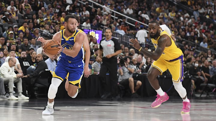 Golden State Warriors guard Curry drives past Los Angeles Lakers forward James in the second quarter during a preseason game.