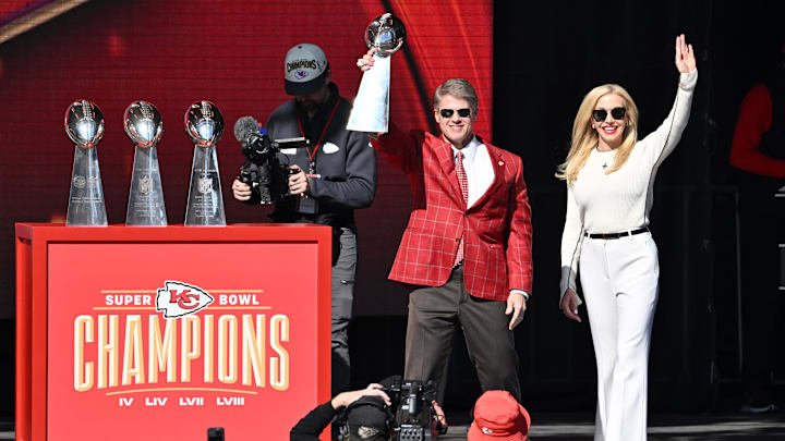 Feb 14, 2024; Kansas City, MO, USA; Kansas City Chiefs chairman and co-owner Clark Hunt holds the Vince Lombardi Trophy on stage with his wife Tavia during the celebration of the Kansas City Chiefs winning Super Bowl LVIII. Mandatory Credit: David Rainey-Imagn Images Feb 14, 2024; Kansas City, MO, USA; Kansas City Chiefs chairman and co-owner Clark Hunt holds the Vince Lombardi Trophy on stage with his wife Tavia during the celebration of the Kansas City Chiefs winning Super Bowl LVIII. Mandatory Credit: David Rainey-Imagn Images