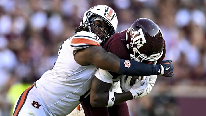 Sep 27, 2025; College Station, Texas, USA; Auburn Tigers linebacker Robert Woodyard Jr. (0) wraps up Texas A&M Aggies running back Le'Veon Moss (8) during the third quarter at Kyle Field. Mandatory Credit: Maria Lysaker-Imagn Images 