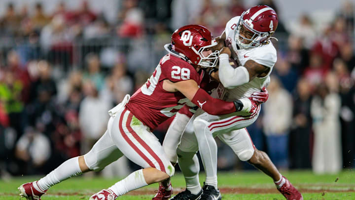 Nov 23, 2024; Norman, Oklahoma, USA; Alabama Crimson Tide quarterback Jalen Milroe (4) is tackled by Oklahoma Sooners linebacker Danny Stutsman (28) during the first quarter at Gaylord Family-Oklahoma Memorial Stadium. Mandatory Credit: William Purnell-Imagn Images Nov 23, 2024; Norman, Oklahoma, USA; Alabama Crimson Tide quarterback Jalen Milroe (4) is tackled by Oklahoma Sooners linebacker Danny Stutsman (28) during the first quarter at Gaylord Family-Oklahoma Memorial Stadium. Mandatory Credit: William Purnell-Imagn Images
