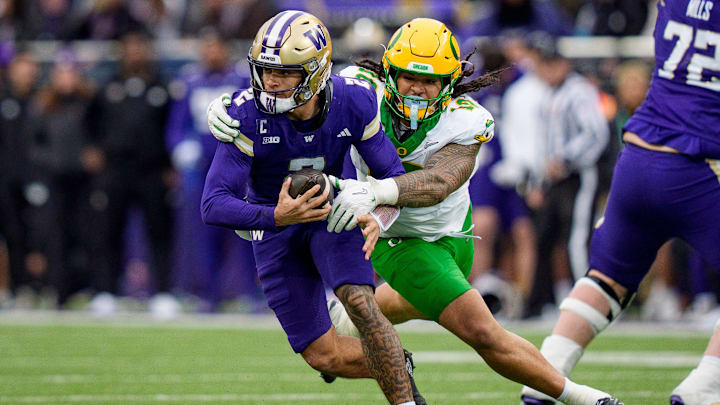 Oregon outside linebacker Matayo Uiagalelei, right, pressures Washington quarterback Demond Williams Jr. as the Oregon Ducks take on the Washington Huskies on Nov. 29, 2025, at Husky Stadium in Seattle, Washington.