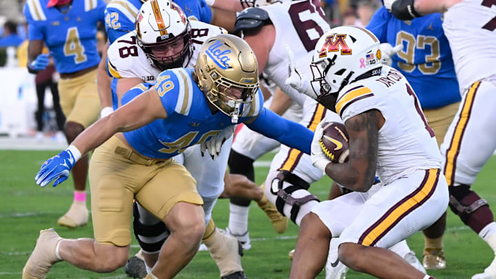 Oct 12, 2024; Pasadena, California, USA; UCLA Bruins linebacker Carson Schwesinger (49) moves to tackle Minnesota Golden Gophers running back Darius Taylor (1) during the first half at Rose Bowl.  