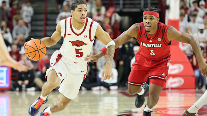 Arkansas Razorbacks guard Darius Acuff Jr (5) drives against Louisville Cardinals guard Ryan Conwell (3) during the first half at Bud Walton Arena. 