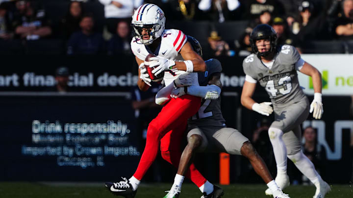 Nov 11, 2023; Boulder, Colorado, USA; Colorado Buffaloes cornerback Travis Hunter (12) tackles Arizona Wildcats wide receiver Tetairoa McMillan (4) in the second half at Folsom Field. Mandatory Credit: Ron Chenoy-Imagn Images