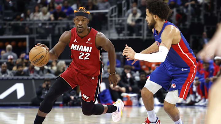 Dec 16, 2024; Detroit, Michigan, USA;  Miami Heat forward Jimmy Butler (22) dribbles as Detroit Pistons guard Cade Cunningham (2) defends in the first half at Little Caesars Arena. Mandatory Credit: Rick Osentoski-Imagn Images