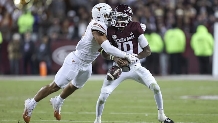 Nov 30, 2024; College Station, Texas, USA; Texas Longhorns linebacker Trey Moore (8) strips the ball away from Texas A&M Aggies quarterback Marcel Reed (10) during the fourth quarter at Kyle Field. Mandatory Credit: Troy Taormina-Imagn Images