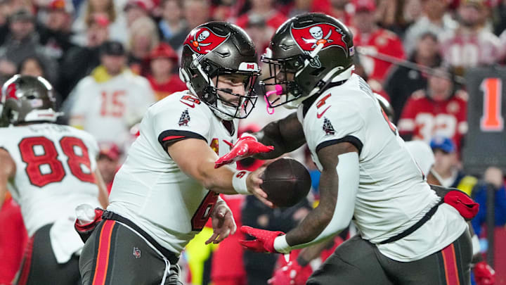 Nov 4, 2024; Kansas City, Missouri, USA; Tampa Bay Buccaneers quarterback Baker Mayfield (6) hands off to running back Bucky Irving (7) against the Kansas City Chiefs during the first half at GEHA Field at Arrowhead Stadium. Mandatory Credit: Denny Medley-Imagn Images