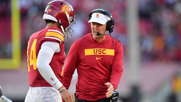 Nov 16, 2024; Los Angeles, California, USA; Southern California Trojans head coach Lincoln Riley greets quarterback Jayden Maiava (14) after scoring a touchdown against the Nebraska Cornhuskers during the second half at the Los Angeles Memorial Coliseum. Mandatory Credit: Gary A. Vasquez-Imagn Images