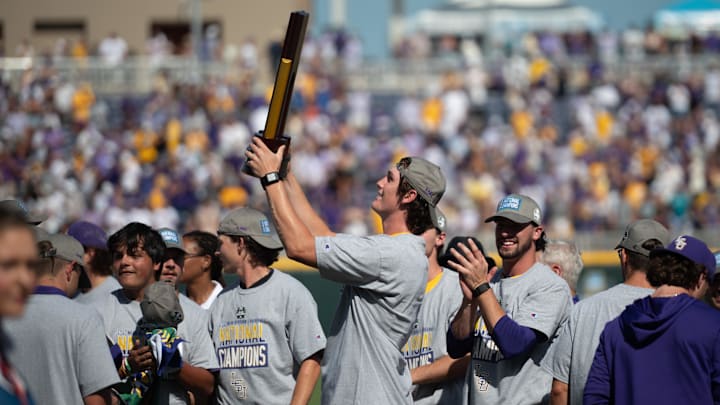 Jun 22, 2025; Omaha, Neb, USA;  LSU Tigers pitcher Chase Shores (34) holds up the championship trophy after the win against the Coastal Carolina Chanticleers at Charles Schwab Field. Mandatory Credit: Steven Branscombe-Imagn Images