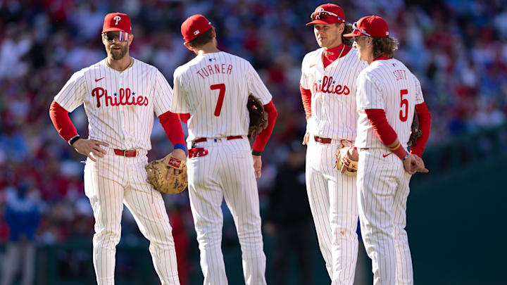 Mar 29, 2024; Philadelphia, Pennsylvania, USA; Philadelphia Phillies first baseman Bryce Harper (3) and shortstop Trea Turner (7) and first baseman Alec Bohm (28) and second baseman Bryson Stott (5) stand together during a pitching change against the Atlanta Braves at Citizens Bank Park.