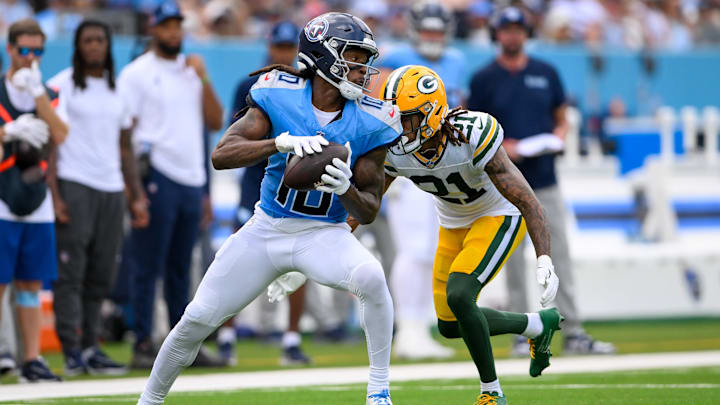 Sep 22, 2024; Nashville, Tennessee, USA;  Tennessee Titans wide receiver DeAndre Hopkins (10) makes a catch as Green Bay Packers cornerback Eric Stokes (21) converses during the first half at Nissan Stadium.