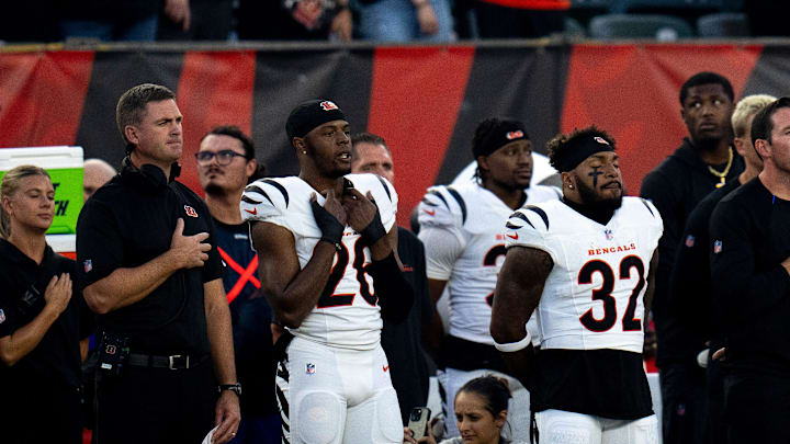 Cincinnati Bengals head coach Zac Taylor, Cincinnati Bengals safety Tycen Anderson (26) and Cincinnati Bengals halfback Trayveon Williams (32) look on during the National Anthem before the NFL preseason game between the Cincinnati Bengals and the Indianapolis Colts at Paycor Stadium in Cincinnati on Thursday, Aug. 22, 2024.