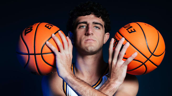 Forward Kyle Evans poses with two basketballs during a UC Irvine photo shoot.