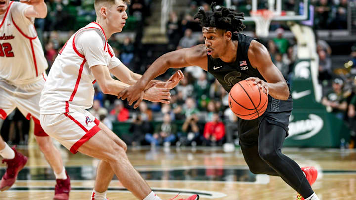Michigan State's A.J. Hoggard, right, moves the ball as Stony Brook's Jared Frey defends during the