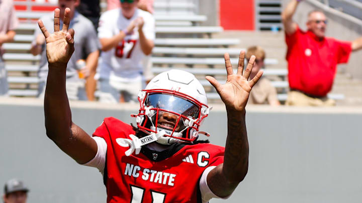 Sep 6, 2025; Raleigh, North Carolina, USA; North Carolina State Wolfpack quarterback CJ Bailey (11) celebrates a touchdown with fans during the first half of the game against Virginia Cavaliers at Carter-Finley Stadium. Mandatory Credit: Jaylynn Nash-Imagn Images