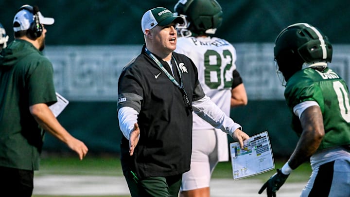 Michigan State's head coach Pat Fitzgerald, left, slaps hands with NiJhay Burt during spring football practice on Tuesday, April 14, 2026, in East Lansing.