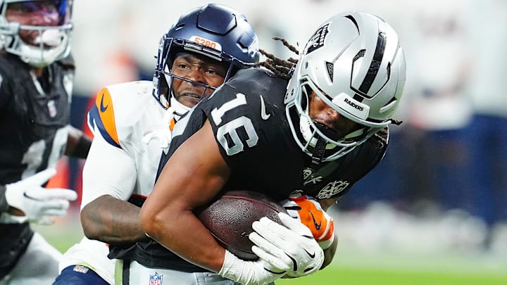 Nov 24, 2024; Paradise, Nevada, USA; Denver Broncos cornerback Ja'Quan McMillian (29) tackles Las Vegas Raiders wide receiver Jakobi Meyers (16) during the fourth quarter at Allegiant Stadium. 