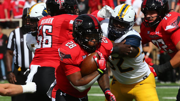 Texas Tech Red Raiders running back Tahj Brooks (28) rushes against West Virginia Mountaineers defensive lineman Asani Redwood (92).