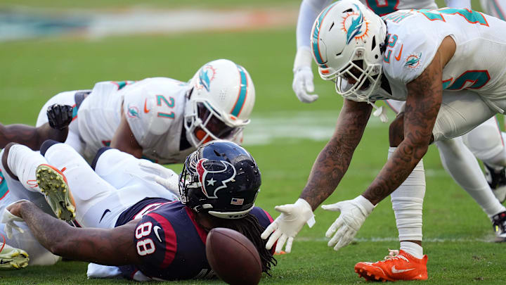 Miami Dolphins cornerback Xavien Howard (25) picks up a fumble by Houston Texans tight end Jordan Akins (88) after getting hit by safety Eric Rowe (21). Howard returned the fumble for a touchdown on the play during the first half of an NFL game at Hard Rock Stadium in Miami Gardens, Nov. 27, 2022.