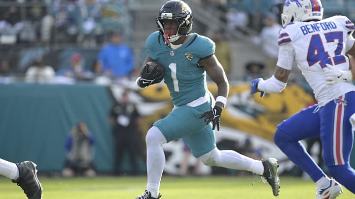 Jan 11, 2026; Jacksonville, FL, USA; Jacksonville Jaguars running back Travis Etienne Jr. (1) runs with the ball during the second half against the Buffalo Bills in an AFC Wild Card Round game at EverBank Stadium. Mandatory Credit: Melina Myers-Imagn Images