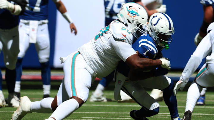 Miami Dolphins defensive tackle Kenneth Grant (90) tackles Indianapolis Colts wide receiver Josh Downs (1) during the first quarter at Lucas Oil Stadium.