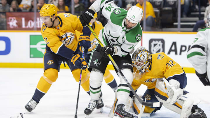 Feb 15, 2024; Nashville, Tennessee, USA; Nashville Predators goalie Kevin Lankinen (32) stops the shot of Dallas Stars left wing Jamie Benn (14) during the second period at Bridgestone Arena. Mandatory Credit: Steve Roberts-Imagn Images