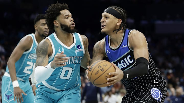 Mar 19, 2026; Charlotte, North Carolina, USA; Orlando Magic forward Paolo Banchero (5) tries to drive to the basket past Charlotte Hornets forward Miles Bridges (0) during the third quarter at Spectrum Center. Mandatory Credit: Brian Westerholt-Imagn Images
